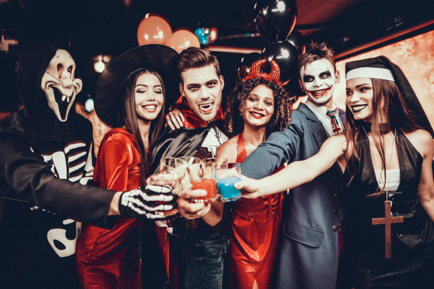Freunde stoßen auf einer Halloween-Party an Freunde stoßen auf einer Halloween-Party an