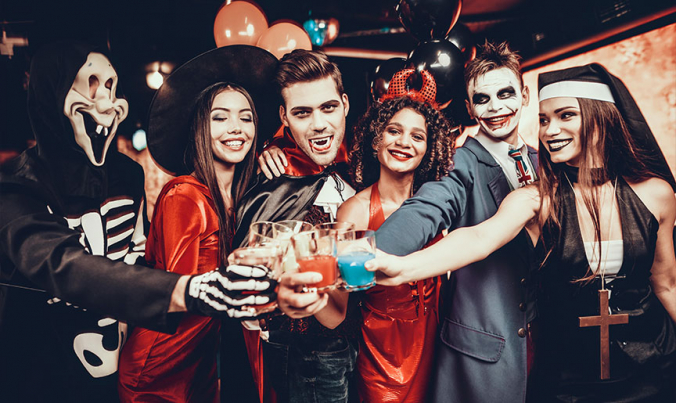 Freunde auf einer Halloween Party in gruseligen Kostümen Freunde auf einer Halloween Party in gruseligen Kostümen